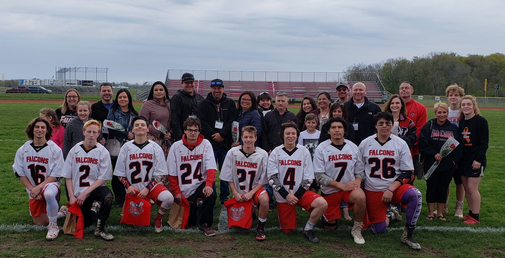 Seniors on the Falcons boys lacrosse team pose with their families. From left, kneeling, Reilly Krupa, Noah Bennett, Jaren Dixon, Wile Chapman, Nick Stott, Eli Dowdy, Devin Napoleon and Jordan Smith. (Photo courtesy of N-W boys lacrosse Twitter account)